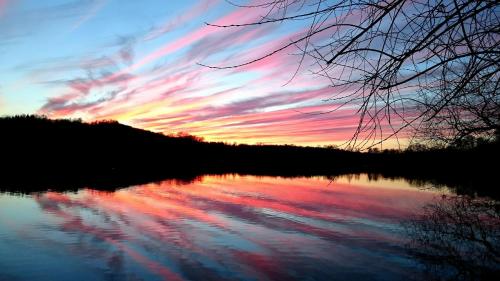 a sunset over a body of water with the sky at Agroturystyka "Jezioranka" in Unichowo