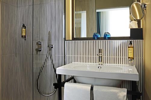 a bathroom with a sink and a mirror and a shower at Best Western Plus Hôtel La Joliette in Marseille