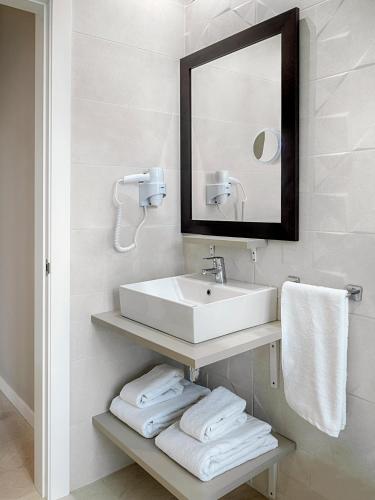 a bathroom with a sink and a mirror and towels at Opera House Valencia B&B in Valencia
