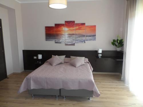 a bedroom with a bed with three paintings on the wall at BELLAVISTA B&b in Lamezia Terme