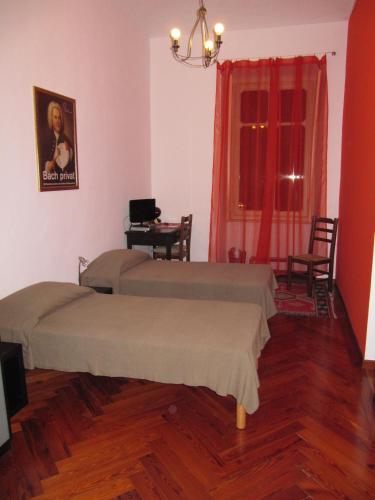 a room with two beds and a table and a window at Al Porta Susa B&B in Turin