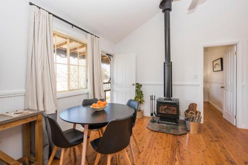 ein Wohnzimmer mit einem Tisch und einem Herd in der Unterkunft Peppertree Farm Mudgee in Mudgee