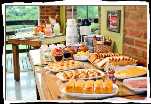 ein Buffet mit vielen Tellern mit Essen auf einem Tisch in der Unterkunft Bina's Haus Pousada, Cafeteria e Atelier in Nova Petrópolis