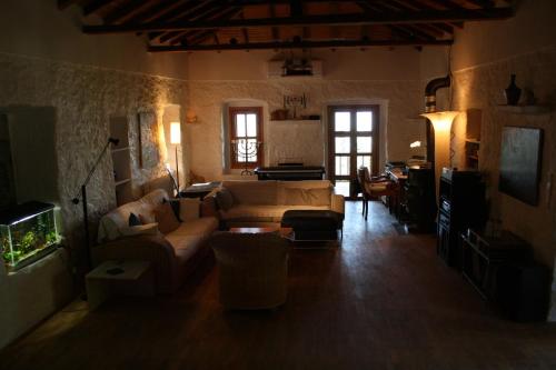 a living room with two couches and a tv at Studios Kyparissi & Spa in Tiros