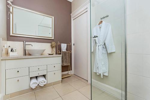 a bathroom with a shower and a sink and a mirror at Topiary Haven in Launceston