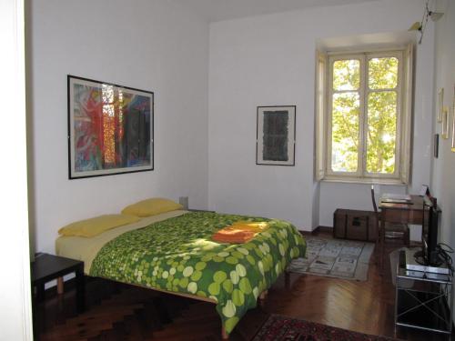 a bedroom with a bed with a green comforter at Al Porta Susa B&B in Turin