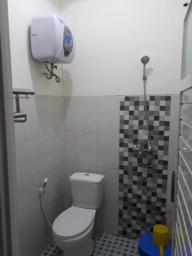 a bathroom with a toilet and a water tank at Villa Puncak Garuda A5 in Batu