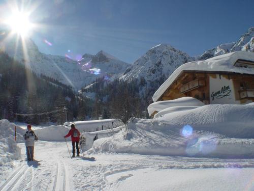 two people on skis in the snow near a ski lodge at Alpengasthof Gern Alm in Pertisau