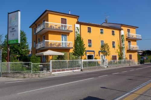 a yellow building on the side of a street at Hotel Bardolino in Bardolino
