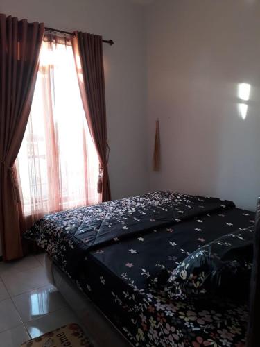 uma cama num quarto com uma janela em Villa Puncak Garuda A5 em Batu