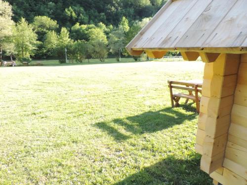 a wooden bench sitting in the grass in a field at Camp Vrbas in Rekavice