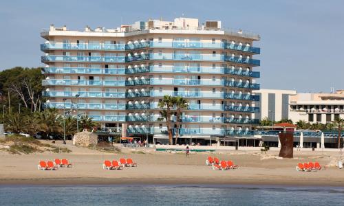 un gran edificio en la playa con sillas y gente en Golden Donaire Beach, en La Pineda