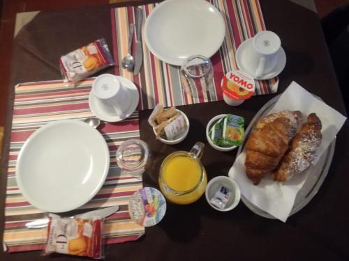 a table with a breakfast of croissants and orange juice at Hotel da Renato in Albinia