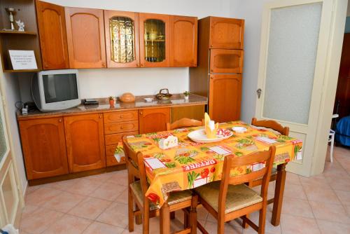 a kitchen with a table with chairs and a television at Casa Duran in Marettimo