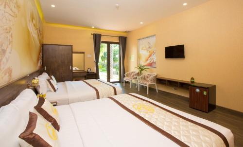 a hotel room with two beds and a television at Sang Như Ngọc Resort in Chau Doc