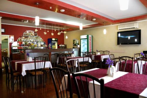 a restaurant with tables and chairs and a bar at Hotel Tourist in Rivne