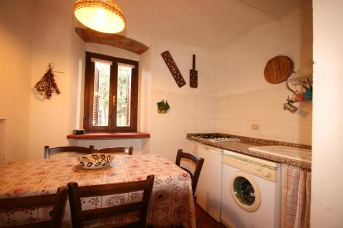 una cucina con tavolo e lavatrice di Terrazza e Vista Mare a Castagneto Carducci
