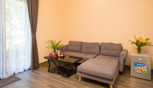 a living room with a couch and a table at Sang Như Ngọc Resort in Chau Doc