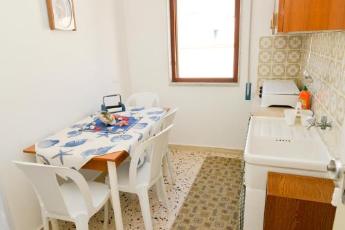 eine Küche mit einem Tisch, Stühlen und einem Waschbecken in der Unterkunft Casa Duran in Marettimo