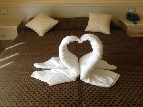 two swans making a heart on a bed with towels at B&B San Matteo in Scalea