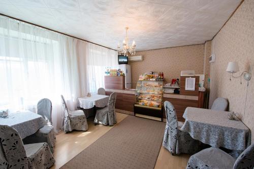 un restaurante con 2 mesas y sillas y una ventana en Centralnaya Hotel, en Novosibirsk