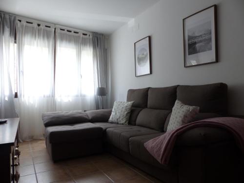 a living room with a couch and a window at Apartament Valls d'Aneu in Esterri d'Àneu