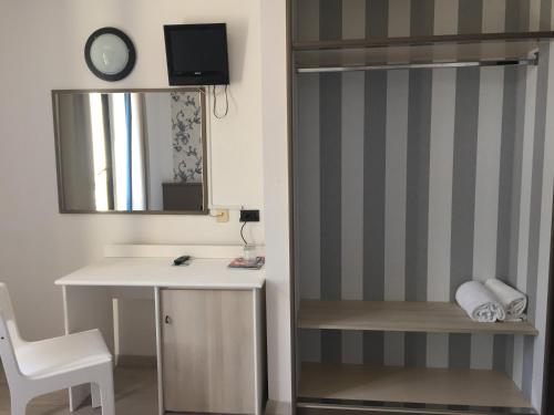 een kamer met een bureau, een spiegel en een stoel bij Hotel Plaza in Desenzano del Garda