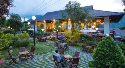 a group of people sitting in chairs in front of a building at Sang Như Ngọc Resort in Chau Doc
