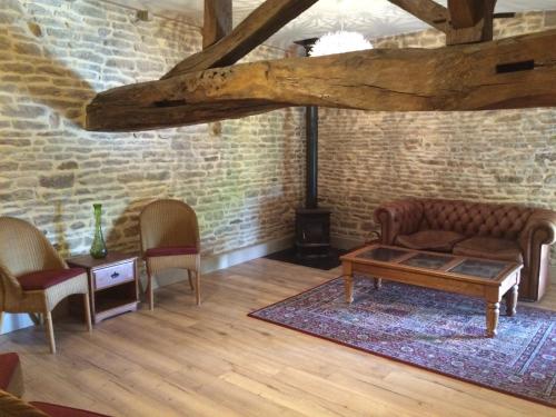 a living room with a couch and chairs and a table at Les Portails Bleus in Azé