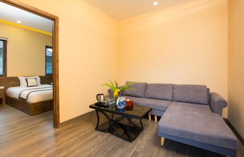 a living room with a blue couch and a mirror at Sang Như Ngọc Resort in Chau Doc