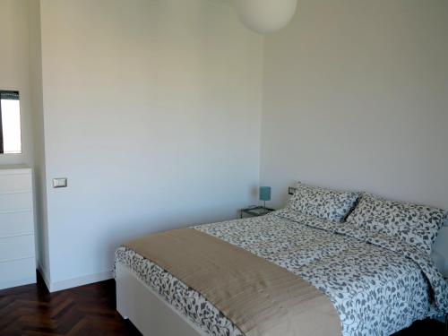 um quarto com uma cama e uma parede branca em Pretty panoramic apartment - half way Center-Vomero district em Nápoles