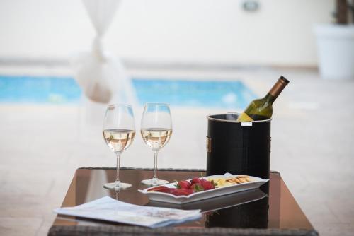 a table with two glasses of wine and a plate of food at Luxury Villa Regina in Protaras