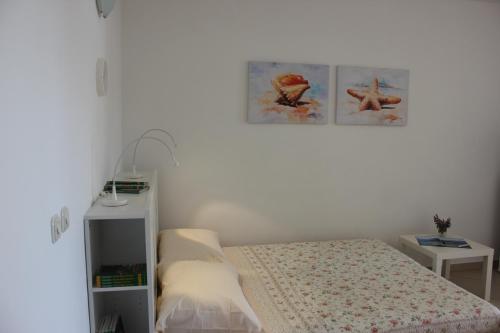 1 dormitorio con 1 cama y 2 cuadros en la pared en Apartments Oaza Regi en Medulin