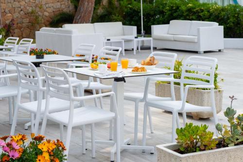 a white table and chairs on a patio at Hotel Vibra Marco Polo I - Adults only in San Antonio