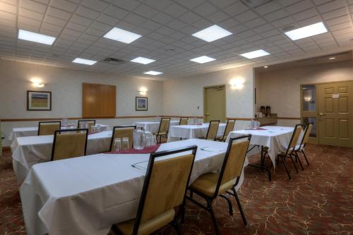 a dining room with white tables and chairs at Country Inn & Suites by Radisson, Calgary-Northeast in Calgary