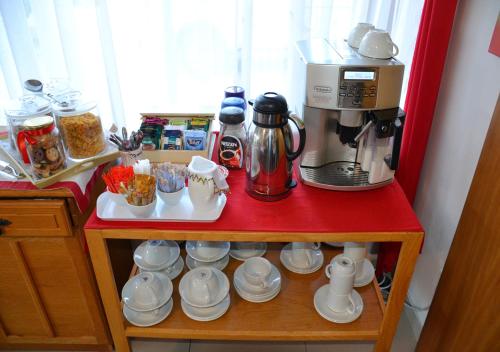 a red counter top with a coffee maker and cups at Golfer's Lodge in Edenvale