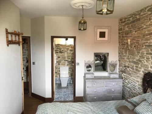 a bedroom with a bed and a stone wall at Glatigny Farmhouse - close to beach - proche de la plage in Glatigny