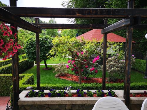 a garden with flowers and a wooden pergola at Villa Onix in Sinaia