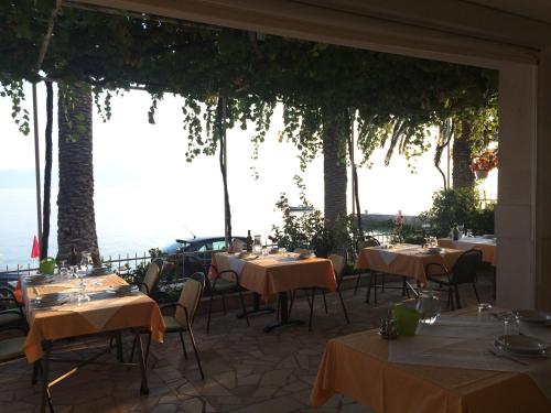 - un restaurant avec des tables et des chaises offrant une vue sur l'océan dans l'établissement Apartments Pansion Franka, à Brist