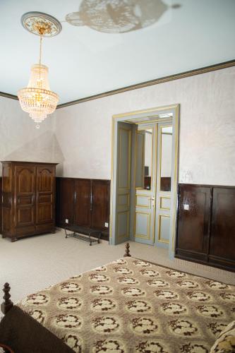 a bedroom with a bed and a chandelier at NF Palace Old City Bucharest in Bucharest