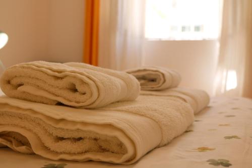 a row of towels sitting on top of a bed at Casa Malpique in Albufeira