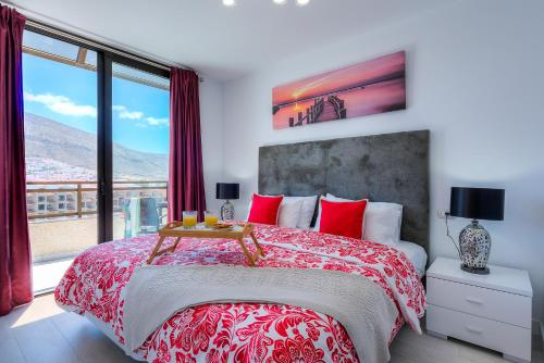 ロス・クリスティアーノスにあるModern Apartment Los Cristianos Centerのベッドルーム1室(大型ベッド1台、赤い枕付)