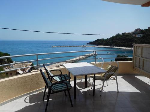 a table and chairs on a balcony overlooking the ocean at Harbour View - Oceanis Apartments in Poros
