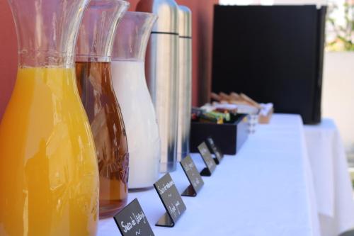 a table with two vases of orange juice on it at Casa Malpique in Albufeira