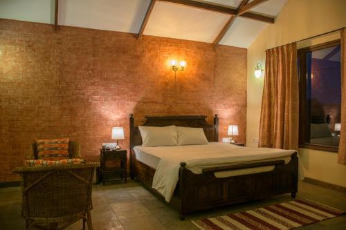 a bedroom with a bed and a brick wall at Hathi Mauja in Jaipur