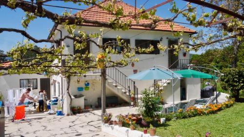 a white house with a porch and a patio at Casa das Lages in Paredes de Coura