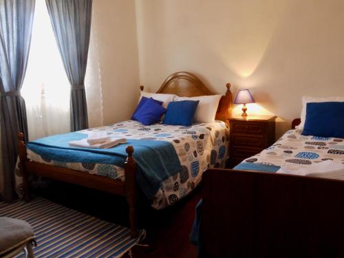 a bedroom with two beds and a window at Casa das Lages in Paredes de Coura