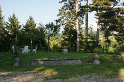 a garden with a bench and chairs in the grass at Tenuta Terensano in Monleale