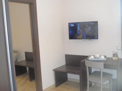 a room with a table and a television on the wall at BELLAVISTA B&b in Lamezia Terme