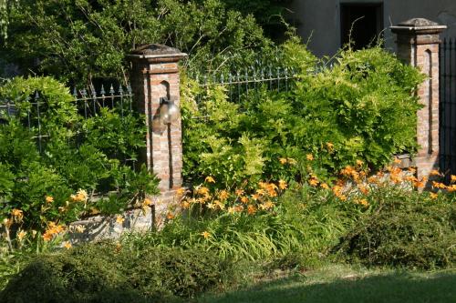 a garden with a brick fence and flowers at Tenuta Terensano in Monleale